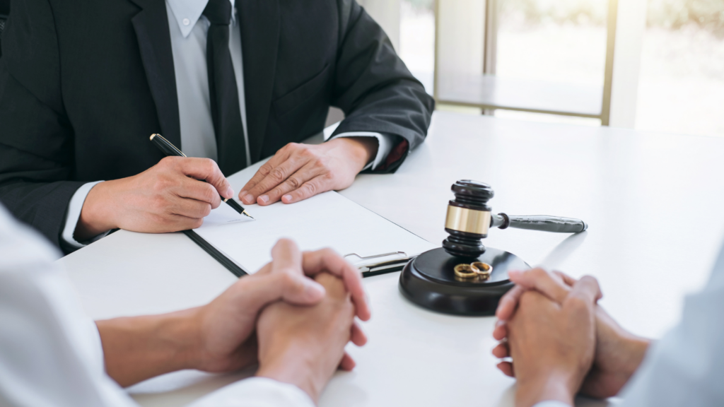 A couple working with a family law attorneys with a gavel resting in the middle of the table.